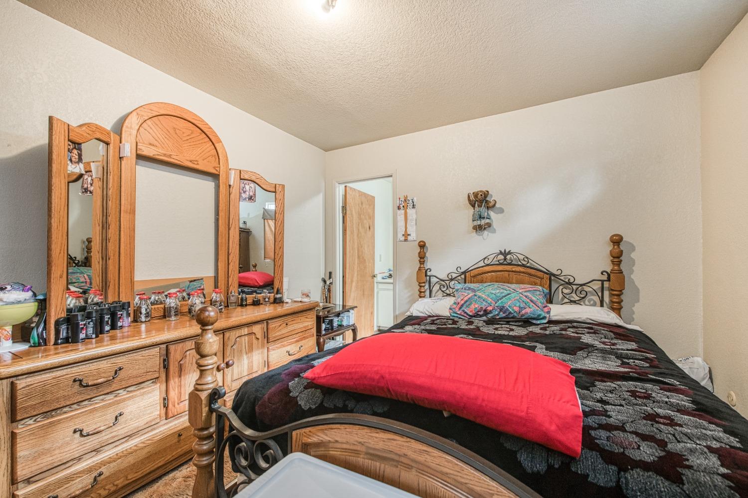 717 Clinton Street Madera, CA 93638 - Photo 24 of 38 a bedroom with bed and a large mirror