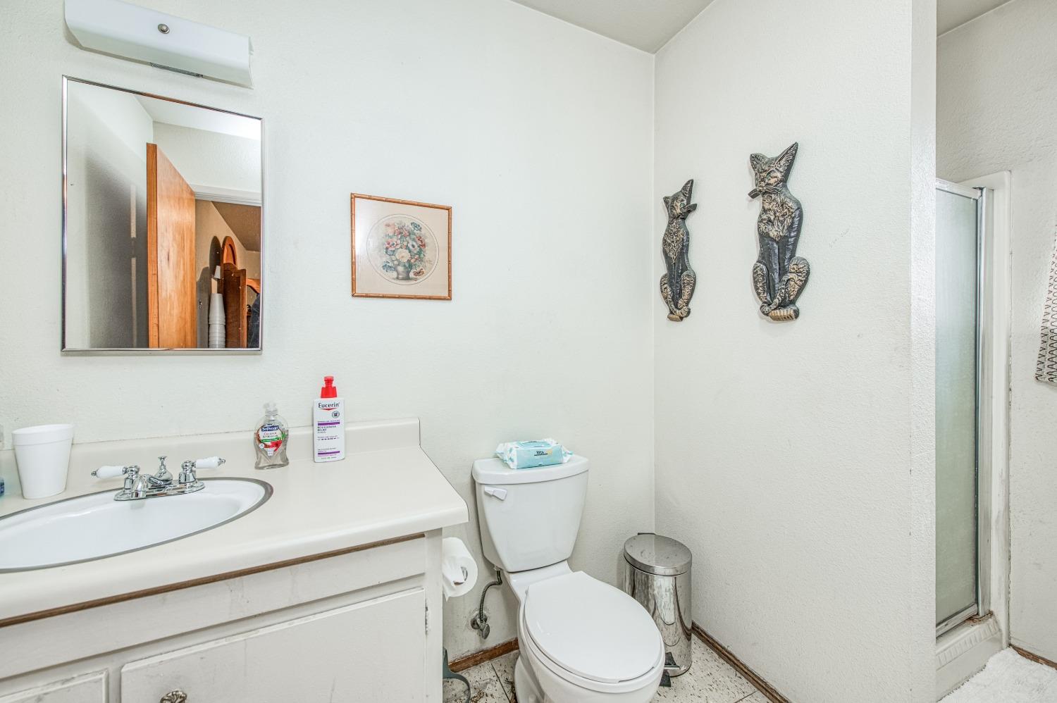 717 Clinton Street Madera, CA 93638 - Photo 25 of 38 a bathroom with a granite countertop toilet sink and mirror