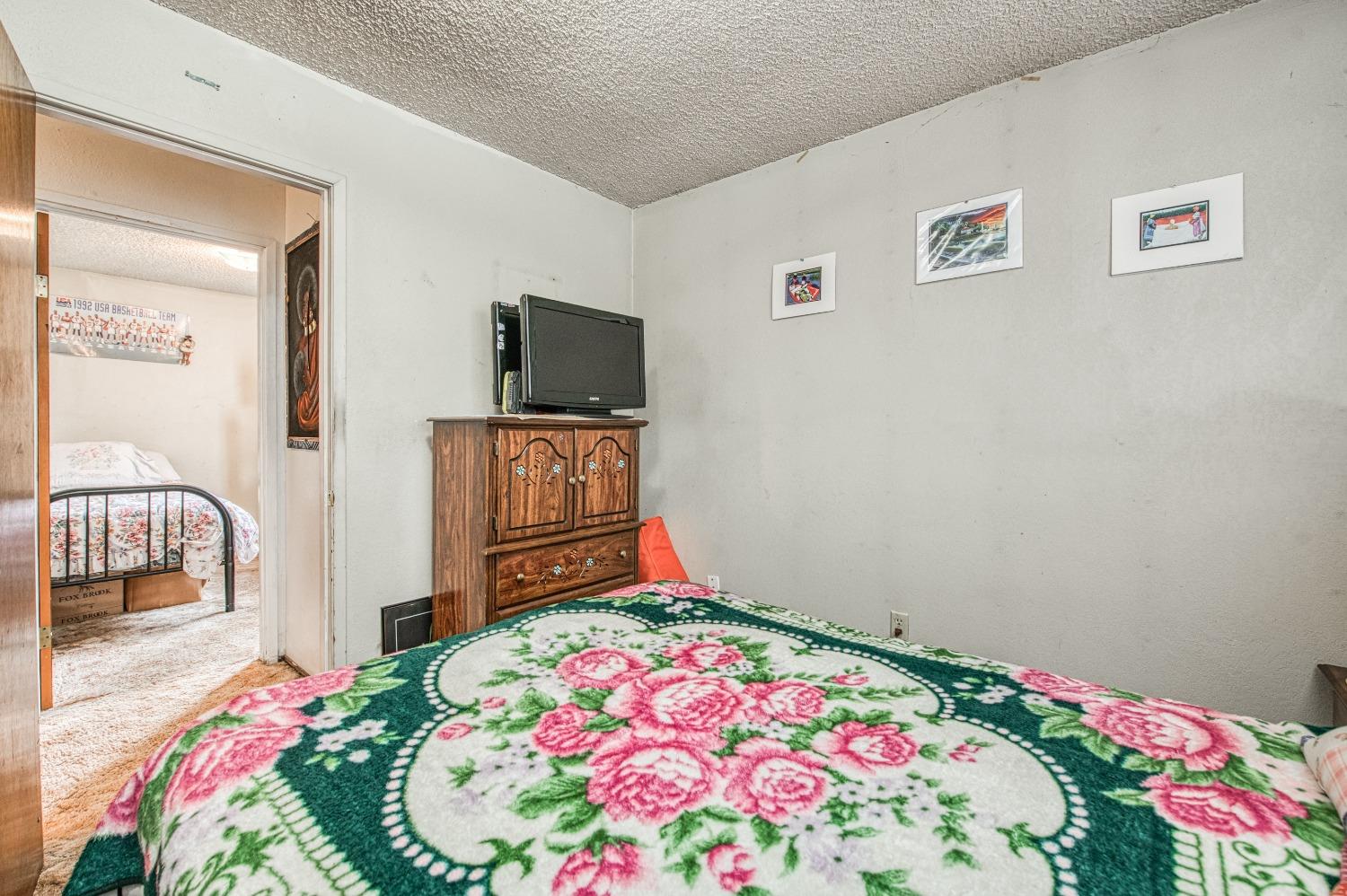 717 Clinton Street Madera, CA 93638 - Photo 27 of 38 a bedroom with a bed and a flat screen tv