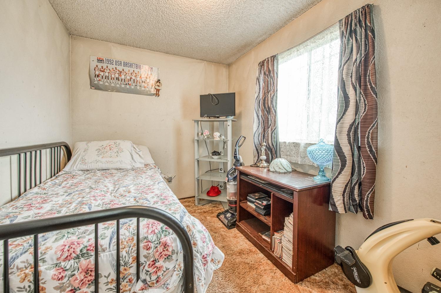 717 Clinton Street Madera, CA 93638 - Photo 28 of 38 a bedroom with a bed and a table in it