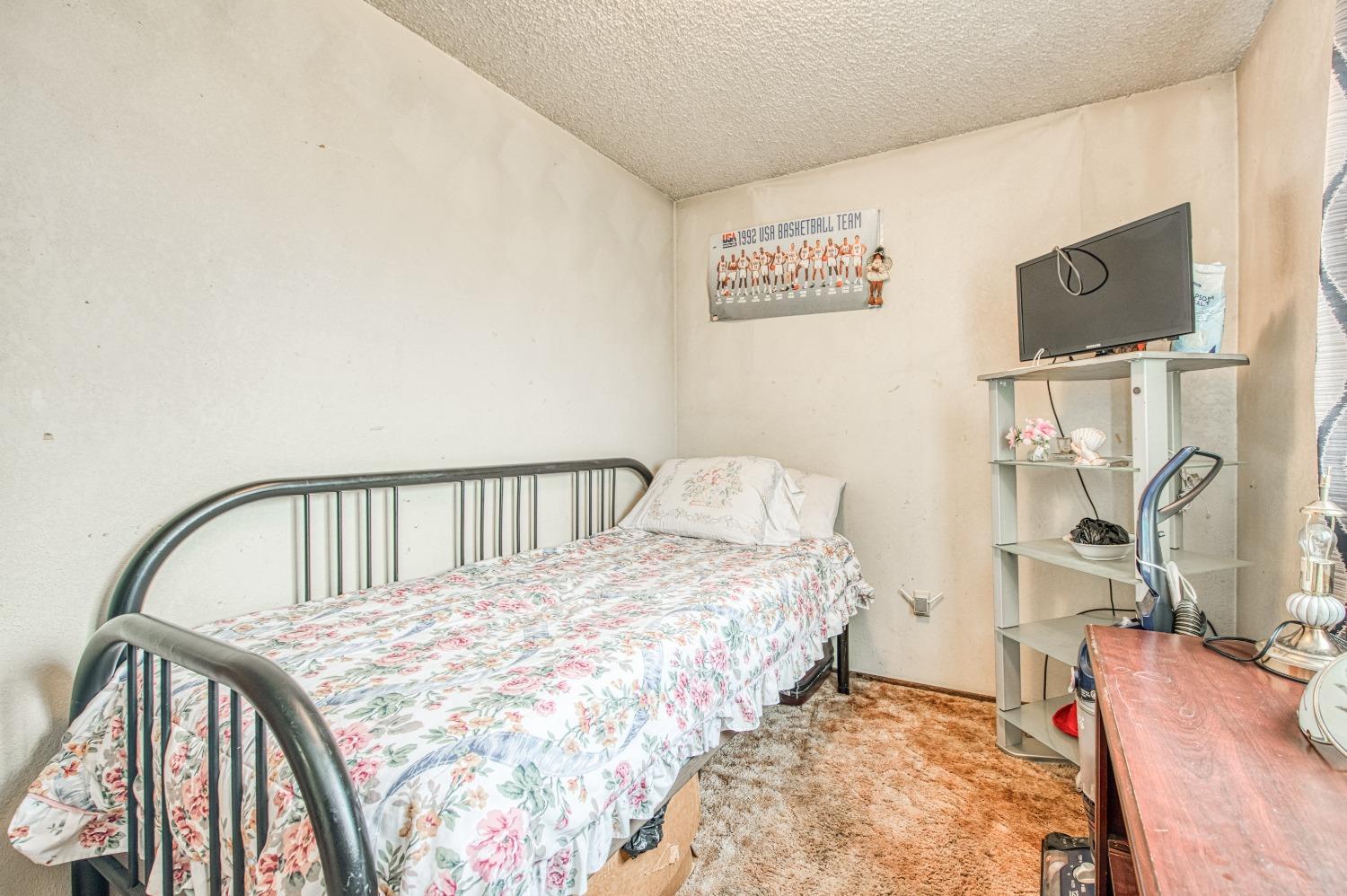 717 Clinton Street Madera, CA 93638 - Photo 29 of 38 a bedroom with a bed and a table in it