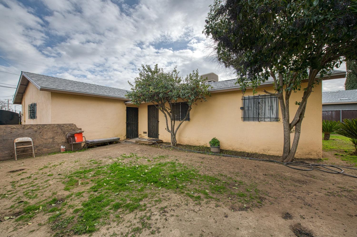 717 Clinton Street Madera, CA 93638 - Photo 34 of 38 a view of a house with backyard and a tree