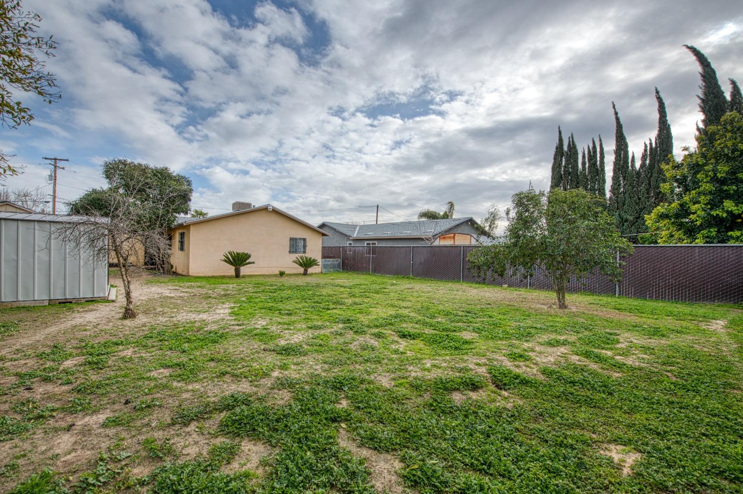 717 Clinton Street Madera, CA 93638 - Photo 36 of 38 a backyard of a house with plants and wooden fence