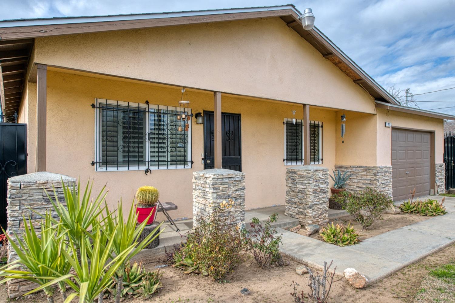 717 Clinton Street Madera, CA 93638 - Photo 6 of 38 a front view of a house with a garden
