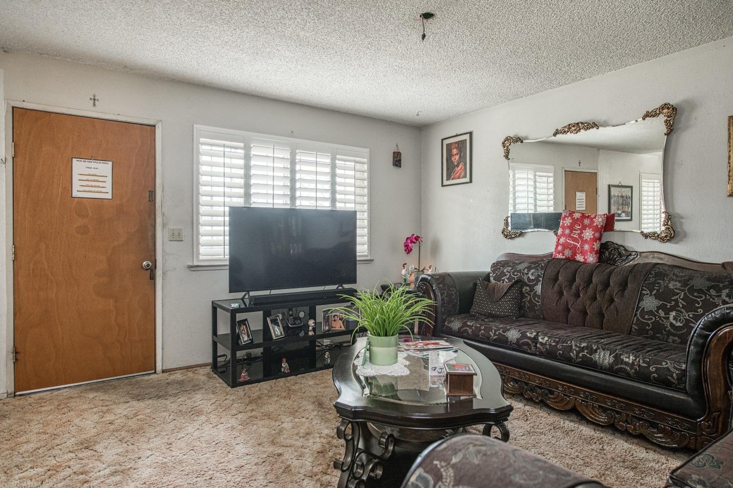 717 Clinton Street Madera, CA 93638 - Photo 8 of 38 a living room with furniture and a flat screen tv