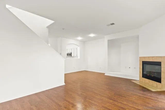 a view of empty room with wooden floor and fireplace