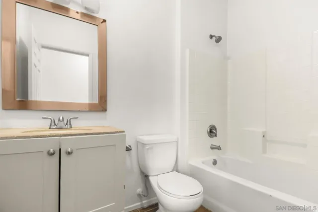 a bathroom with a toilet a sink a mirror and bathtub
