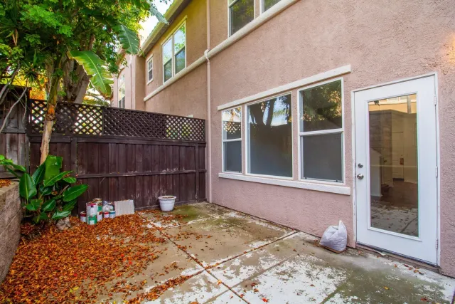 a view of a backyard with a chairs and potted plants