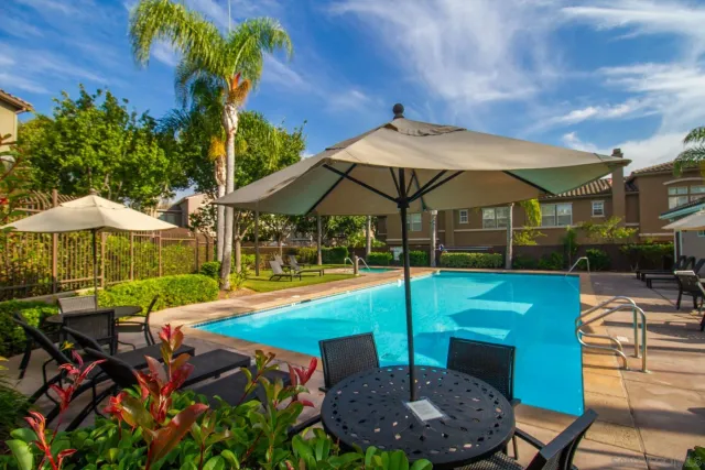 a view of a swimming pool with lawn chairs under an umbrella