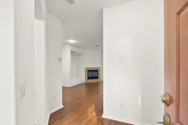a view of a hallway with wooden floor and staircase