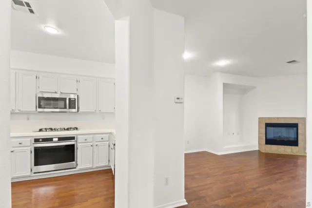 a kitchen with stainless steel appliances a stove a microwave and white cabinets