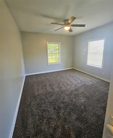 en empty room with windows and fan