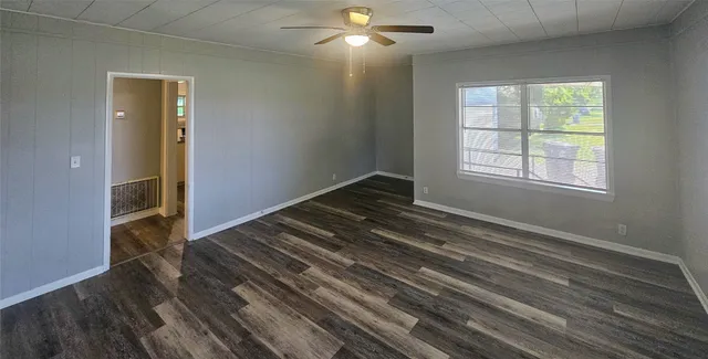 wooden floor in an empty room with a window