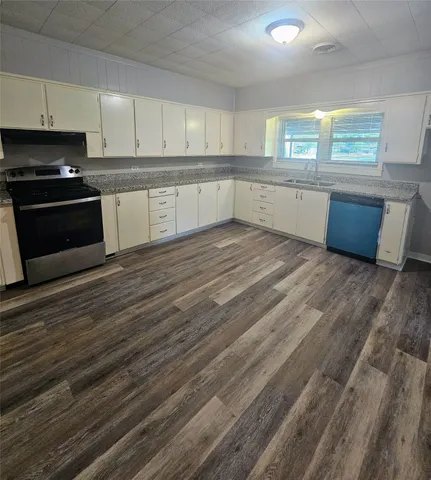 a kitchen with wooden floors and appliances