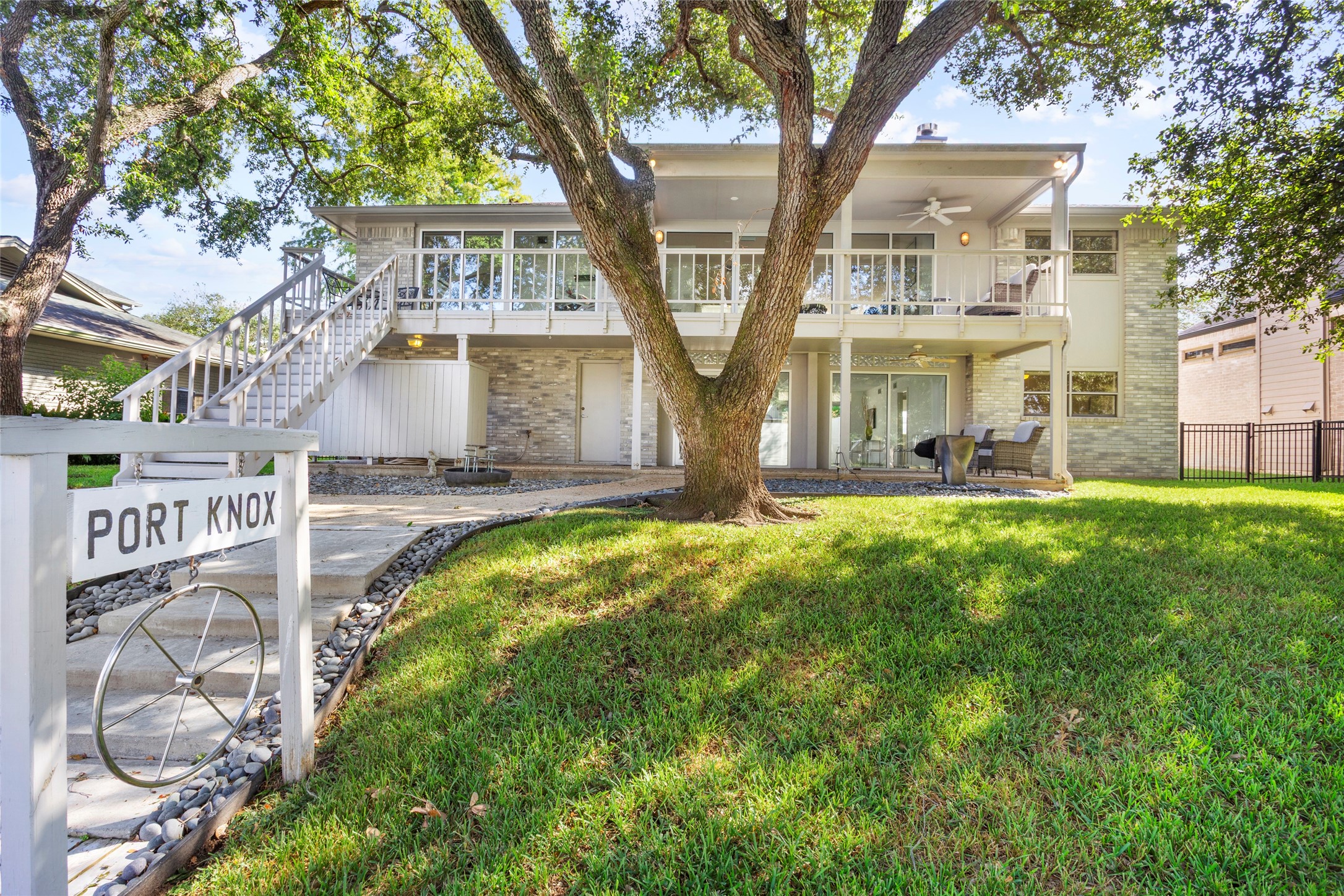 67 Harbor Lane Kemah, TX 77565 - Photo 38 of 47 This inviting two-story home features a modern exterior with large windows and a spacious balcony, perfect for relaxation. Surrounded by lush greenery, it offers a serene ambiance and ample outdoor space for entertaining.