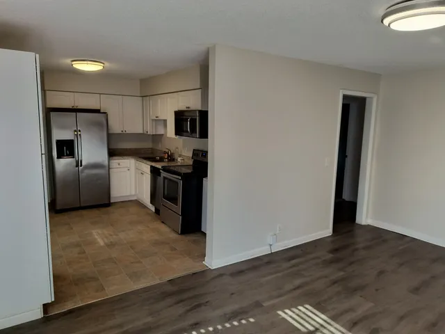 a kitchen with stainless steel appliances granite countertop a refrigerator a stove and a sink