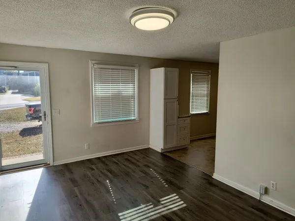 an empty room with wooden floor and windows