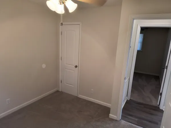an empty room with a window and a fan