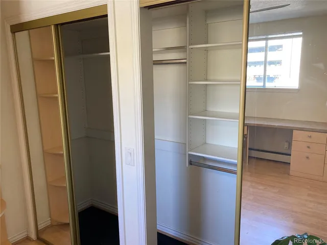 a view of walk in closet with empty racks