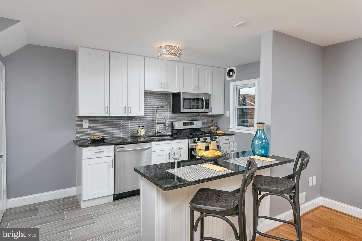 901 Stamford Road Baltimore, MD 21229 - Photo 11 of 27 a kitchen with a table chairs and microwave