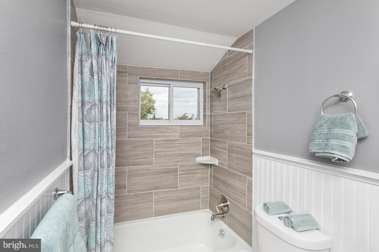 901 Stamford Road Baltimore, MD 21229 - Photo 22 of 27 a bathroom with a window a bathtub and shower