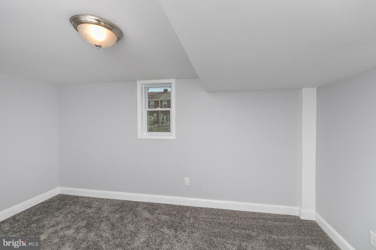 901 Stamford Road Baltimore, MD 21229 - Photo 25 of 27 an empty room with wooden floor and windows