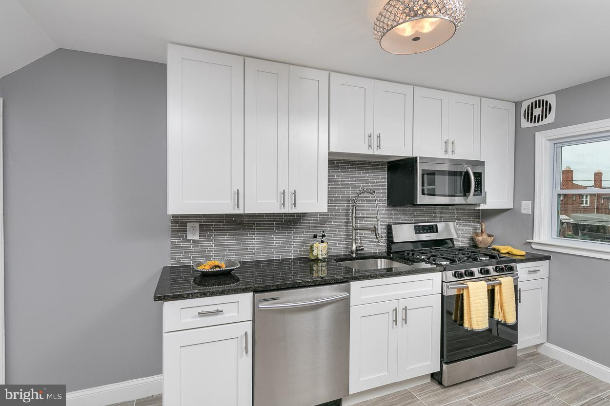901 Stamford Road Baltimore, MD 21229 - Photo 10 of 27 a kitchen with white cabinets stainless steel appliances and sink