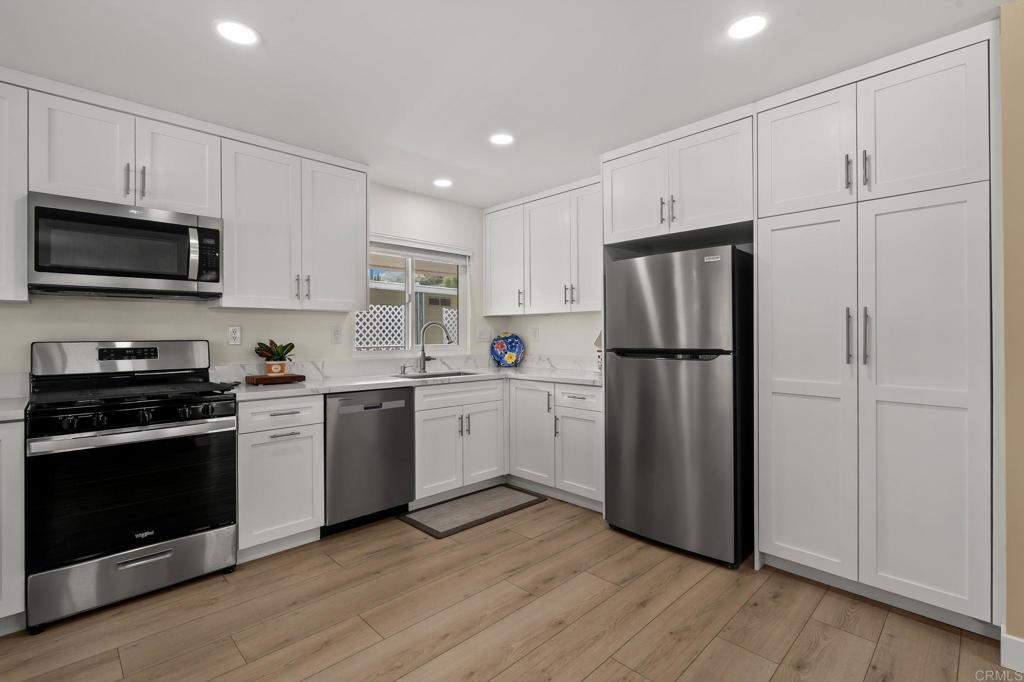 7467 Mission Gorge Road, Unit 104 Santee, CA 92071 - Photo 12 of 25 a kitchen with a refrigerator stove and wooden cabinets
