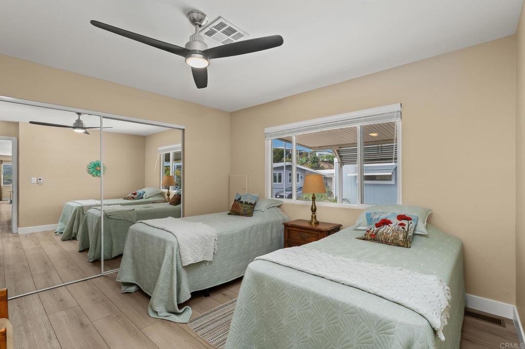 7467 Mission Gorge Road, Unit 104 Santee, CA 92071 - Photo 18 of 25 a bedroom with two beds and a chandelier