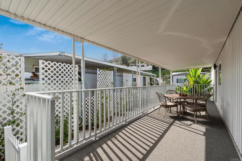 7467 Mission Gorge Road, Unit 104 Santee, CA 92071 - Photo 4 of 25 a balcony with wooden floor table and chairs