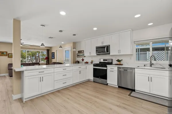a large kitchen with cabinets a sink and appliances