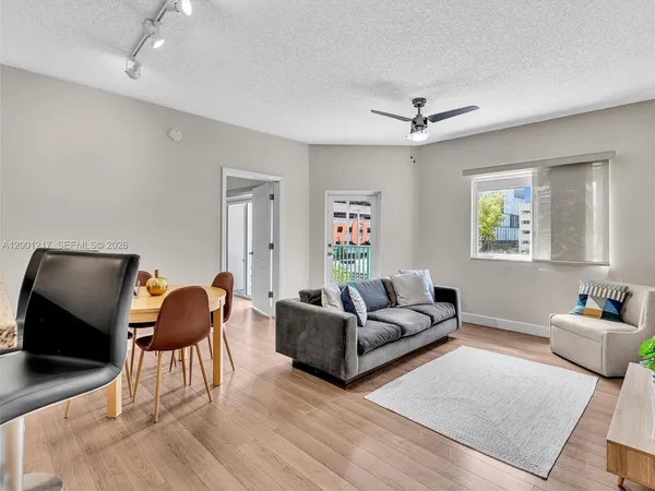 a living room with furniture and a dining table with wooden floor