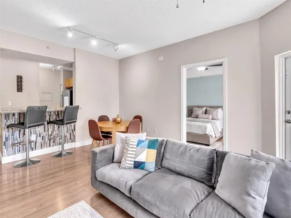 an empty room with wooden floor chandelier fan and windows