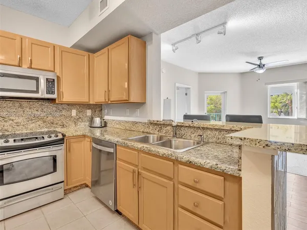 a kitchen with granite countertop a stove sink and cabinets