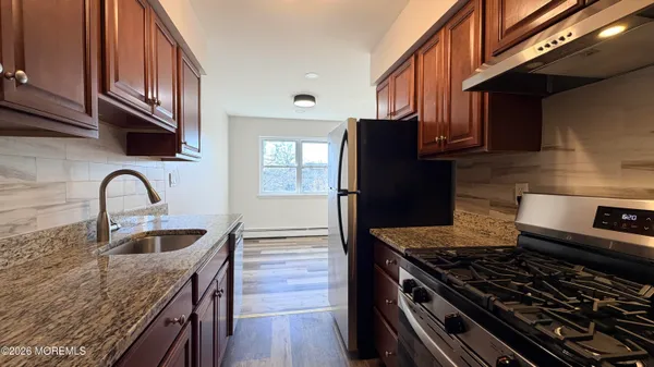 a bathroom with a granite countertop sink a mirror and shower