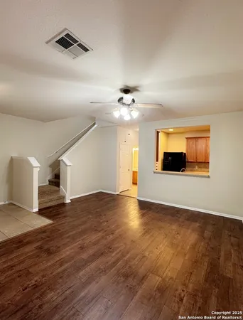 a view of a livingroom with wooden floor and a ceiling fan