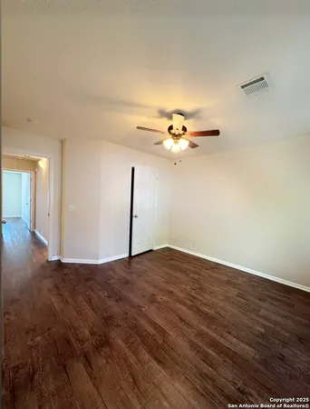 a view of a big room with wooden floor closet and chandelier fan