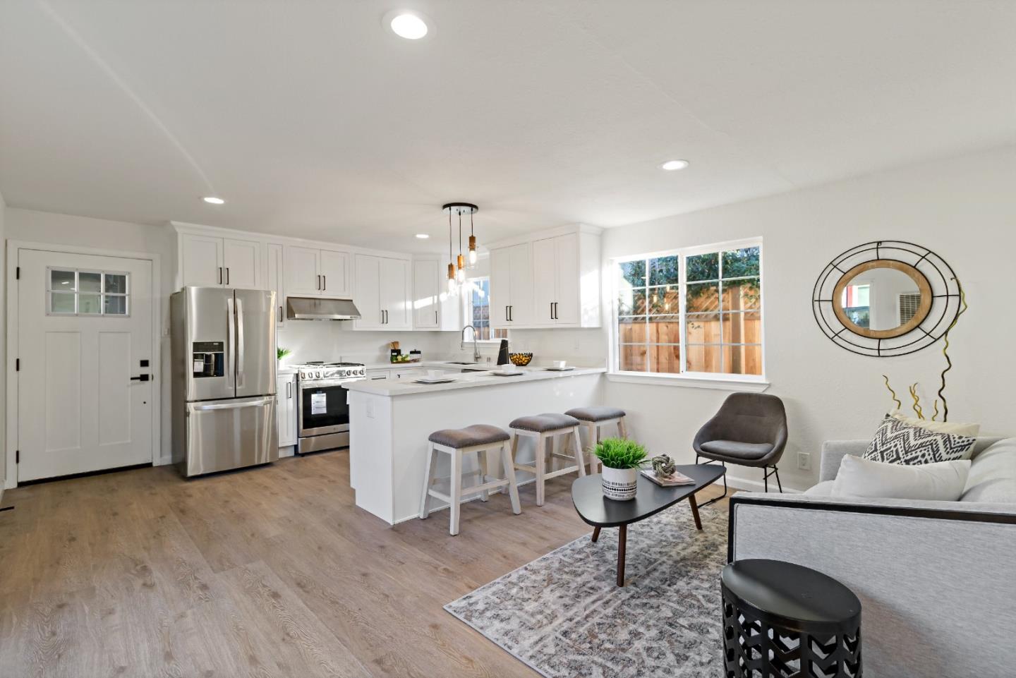 a living room with stainless steel appliances furniture and a view of kitchen