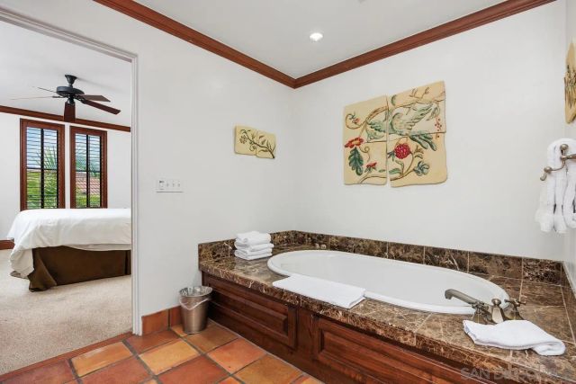 a bathroom with a tub and a painting on the wall