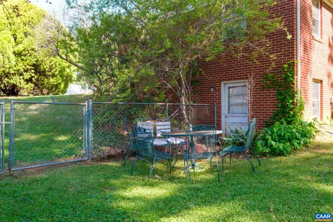 a view of house with backyard and outdoor seating