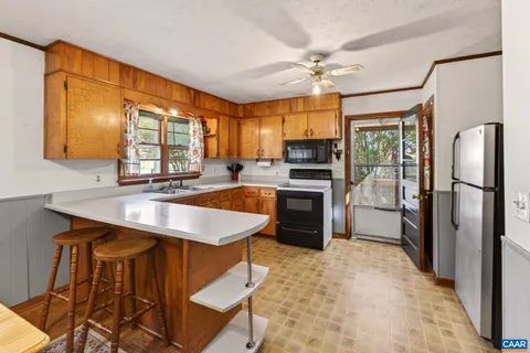 a kitchen with stainless steel appliances granite countertop a sink refrigerator stove and microwave