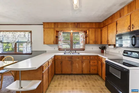 a large kitchen with stainless steel appliances a stove a sink and a microwave
