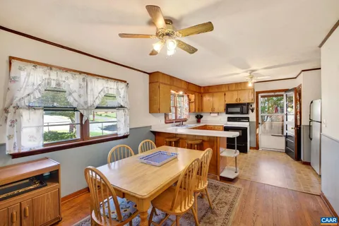 a open kitchen with a table chairs refrigerator and window