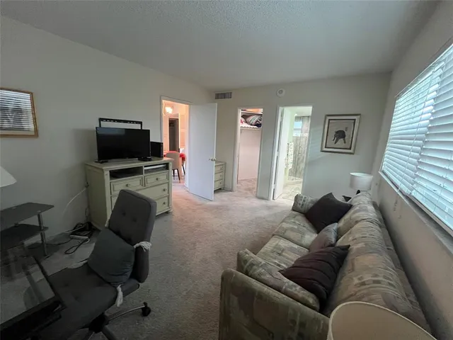 a view of a swimming pool with lawn chairs under an umbrella