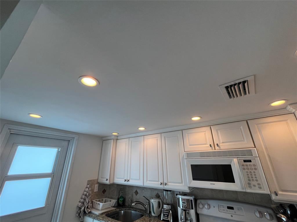 333 Northeast 21st Avenue, Unit 318 Deerfield Beach, FL 33441 - Photo 7 of 40 a view of kitchen with stainless steel appliances wooden floor and seating