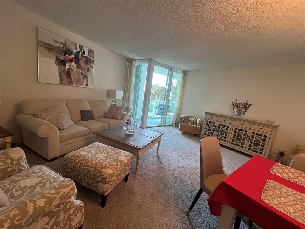 333 Northeast 21st Avenue, Unit 318 Deerfield Beach, FL 33441 - Photo 9 of 40 a living room with furniture and wooden floor