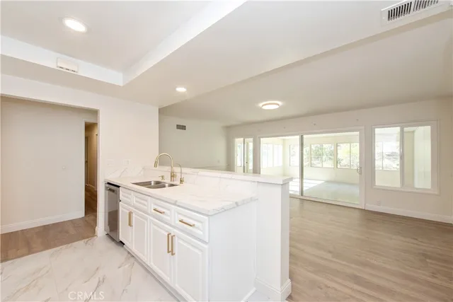 a view of a kitchen counter top space with stainless steel appliances granite countertop a stove and a sink
