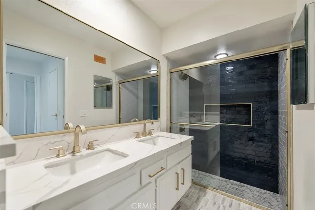 a bathroom with a double vanity sink mirror and shower