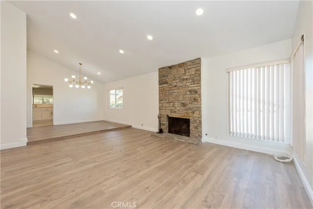 an empty room with wooden floor and fireplace