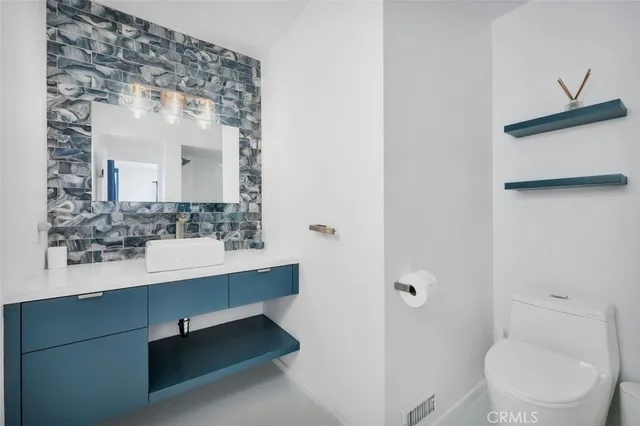 a bathroom with a sink a toilet and mirror